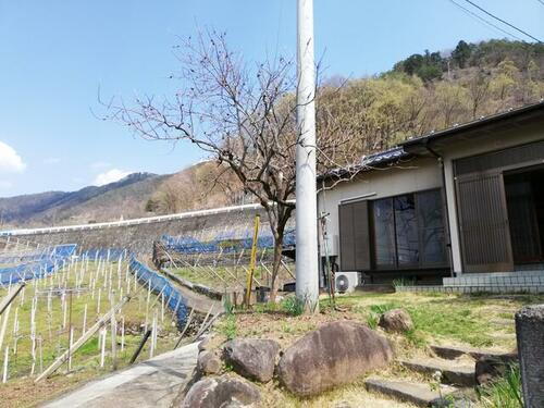 甲府盆地とぶどう畑を眺める　小さな牛奥平屋住宅　倉庫付