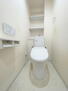 阪神住建グランディール阿倍野 温水洗浄便座付きトイレ。ホワイトカラーで統一され、清潔感のある空間です。上部に棚が設置されています。