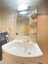 バルミーポート仁方 清潔感あふれる白を基調としたシャワー付洗面台と洗面室。収納棚もある余裕のスペース。洗面台も明るいです