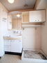 シャルマンコーポ松之浜　　マンション 【洗面室】白でまとめられた洗面室です。洗濯機置き場の上部には、洗剤等を置くのに便利な収納スペースが備わっています。
