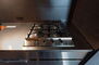 ソルシェ月島 キッチン：4口コンロとステンレスバイブレーション仕上の映えるキッチン。食洗器付き。